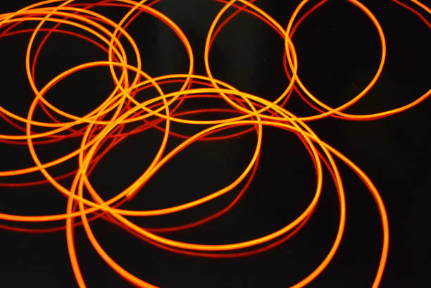 istock Glowing red material, thin bright threads. Burning wire, beautiful textural drawing of light. Art abstraction light fiber, tangle lines and abstraction. 1155912983