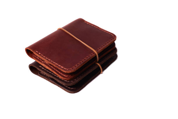istock Handmade two red and brown leather cardholders with rubber band isolated on white background closeup. Stock photo of handmade luxury accessories. 1155913680