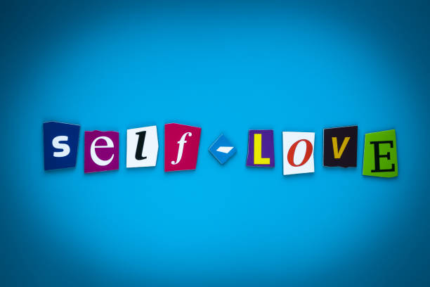 Text Self-Love on blue background from colorful letters. Multicolored inscription on card, banner. Headline, caption, heading. Psychologic concept. Message on poster. stock photo