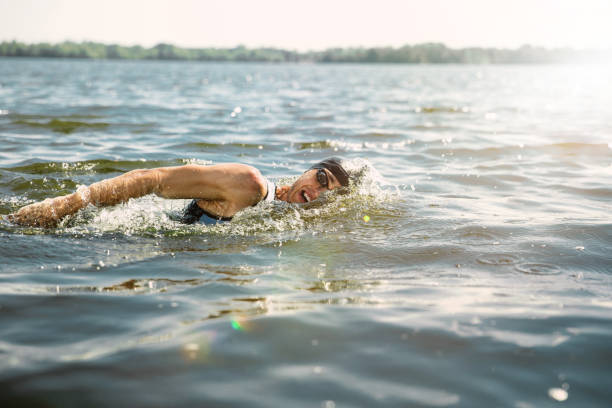 istock Professional triathlete swimming in river's open water 1155914840