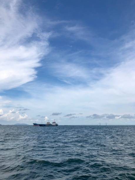 istock Ship on horizon line next to Penang bridge 1155917488
