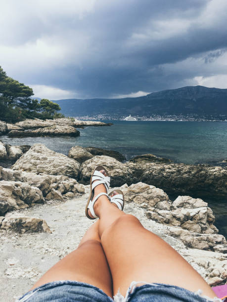 pov of woman relaxing on rocky beach in split, croatia - leg split imagens e fotografias de stock