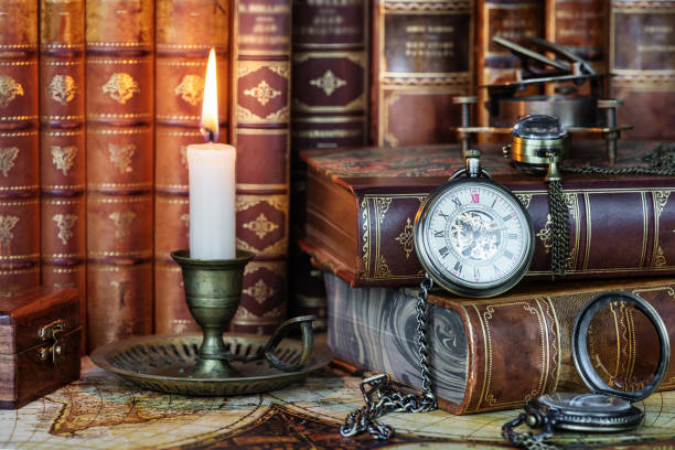 istock Pocket watch, burning candle and old books 1155918864