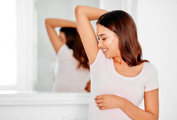 Smooth and fresh just like how I want them Shot of an attractive young woman smelling her underarms in her bathroom at home body odor stock pictures, royalty-free photos & images