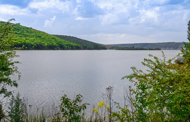 istock Huge sheer stone cliffs on the background of a river Dniester and a blue sky with clouds 1155919797