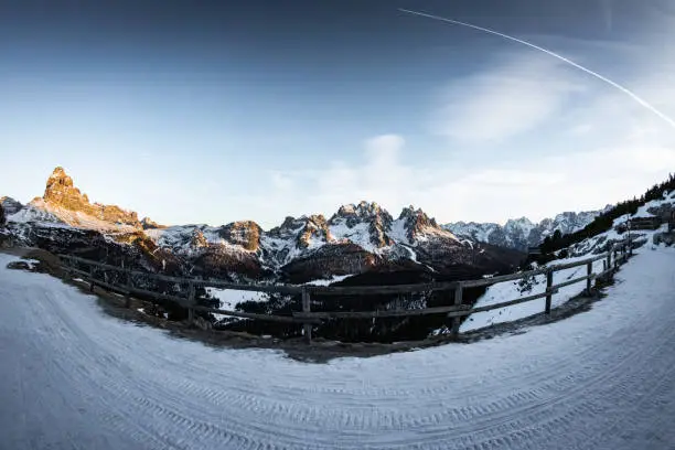 Photo of wonderful fisheye view of scenic snowy landscape in italian dolomites in sunset, peak tre cime di lavaredo in the back