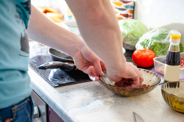 istock young guy in a brightly lit kitchen preparing food 1155924276
