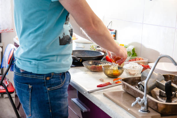 istock young guy in a brightly lit kitchen preparing food 1155924278