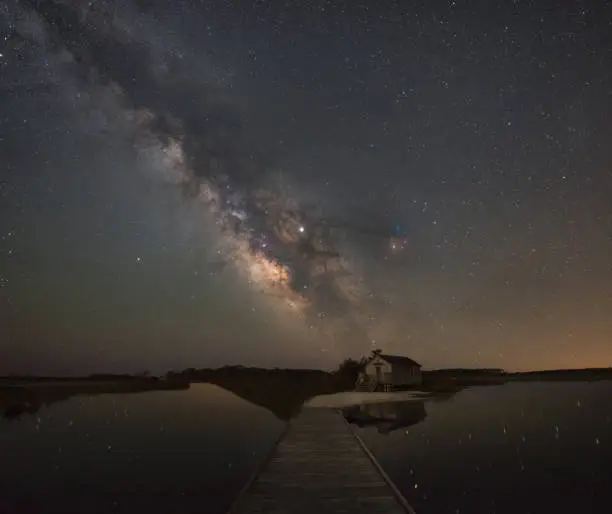 Photo of Boardwalk leading towards the Milky Way and a shack