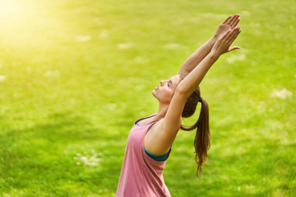 istock Young woman doing yoga in park 1155925334