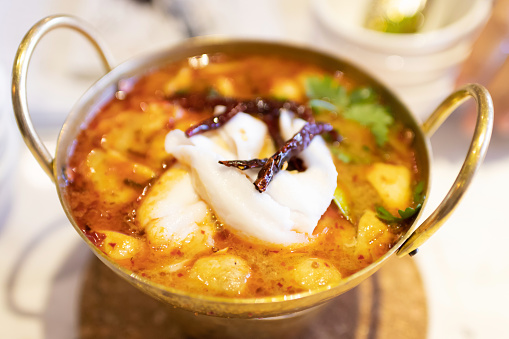 Spicy soup with young coconut meat and fresh herbs 