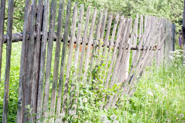 istock old shaky wooden picket fence closeup view 1155926515