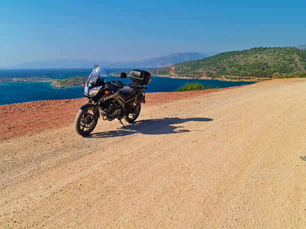 suzuki dl650 (v-strom) motorcycle on dirt road near the sea, sunny summer day. - black blue escape multi colored imagens e fotografias de stock