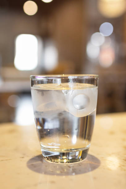 istock Glass of water with ice cubes on marbled table at restaurant. 1155931631