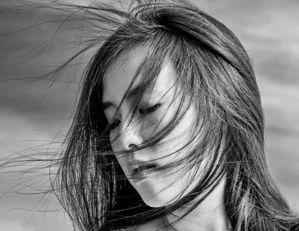 istock Young woman with wind blown hair 1155933566