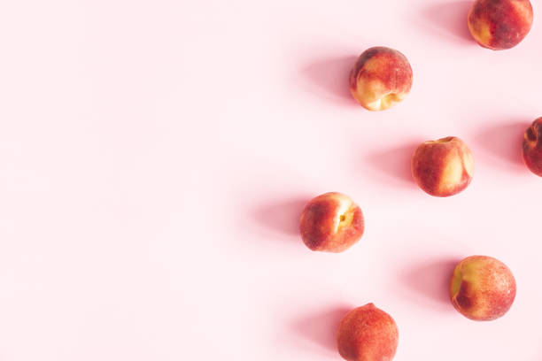 istock Peaches on pastel pink background. Frame made of fresh peaches. Flat lay, top view, copy space 1155939491