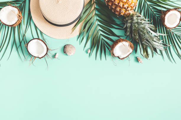 istock Summer composition. Tropical palm leaves, hat, coconut, pineapple on mint background. Summer concept. Flat lay, top view, copy space 1155939898
