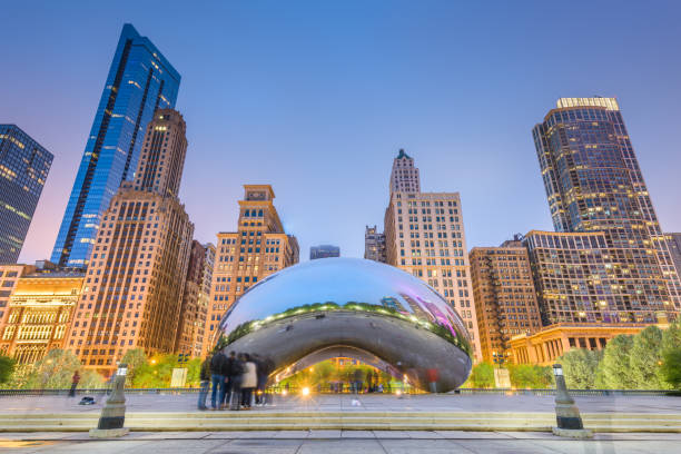 The Bean in Chicago Chicago, Illinois, USA - May 12, 2018: Tourists visit Cloud Gate in Millennium Park in the evening. The sculpture was designed by artist Sir Anish Kapoor and completed in 2006. chicago illinois photos stock pictures, royalty-free photos & images