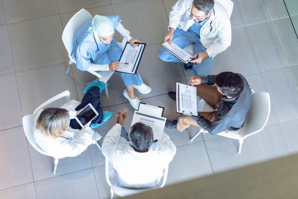 istock Medical team discussing documents with each other in hospital 1155940612
