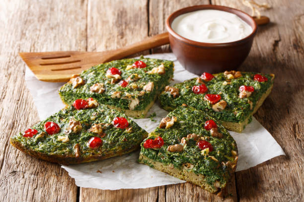 istock Delicious healthy omelette from herbs, eggs and walnuts and dried berries close-up on a table. horizontal 1155942310