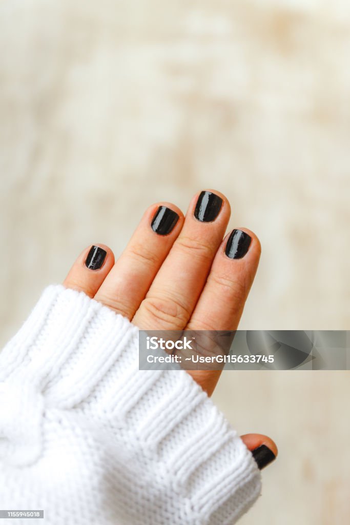 Hand With Black Manicure On Short Nails In A White Sweater On A Light  Background The Concept Of A Stylish And Warm Winter Stock Photo - Download  Image Now - iStock