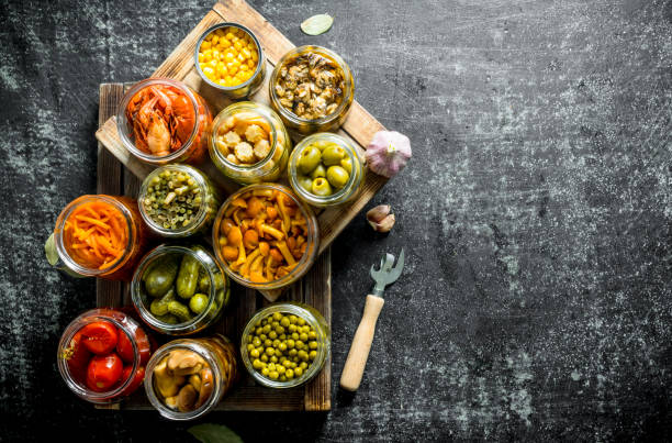 istock Different preserved food on a wooden tray. 1155945136
