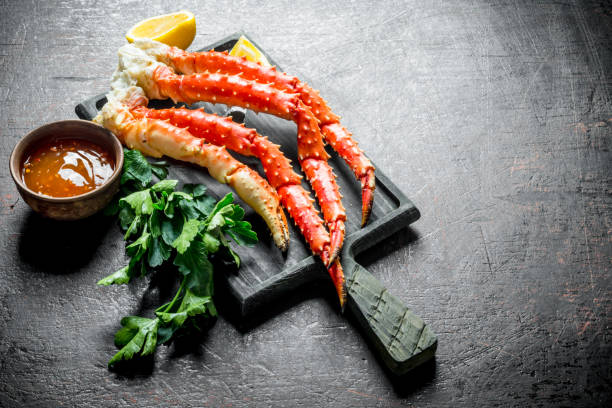 istock Crab on a chopping Board with parsley, sauce and lemon slices. 1155945265