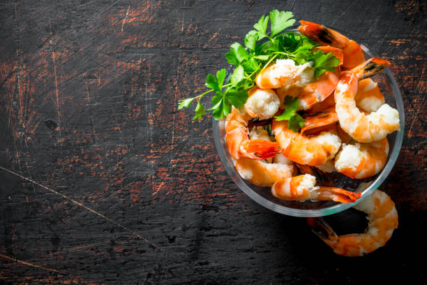 istock Boiled shrimps with glass bowl with parsley. 1155946016
