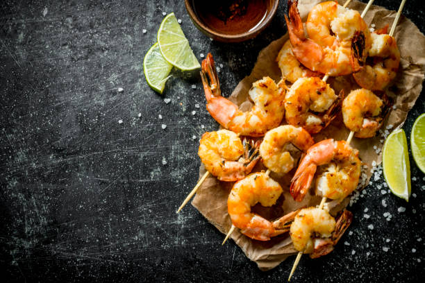 istock Grilled shrimps on paper with the cut lime. 1155946406