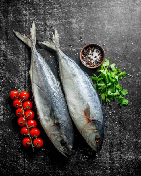 istock Raw fish with parsley, tomatoes and spices. 1155946493