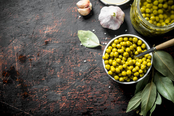 istock Open glass jar with canned green peas. 1155947072