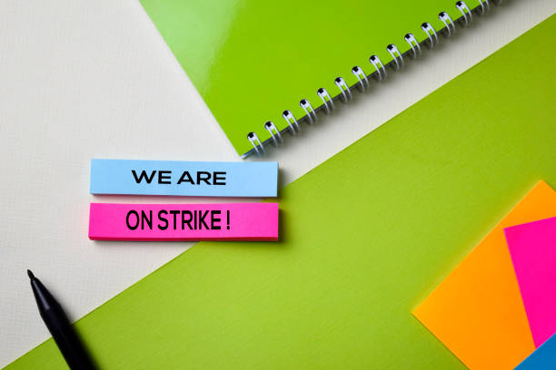 istock We Are on Strike! text on top view office desk table of Business workplace and business objects. 1155947146