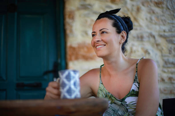istock Smiling woman is drinking coffee at the backyard 1155947258