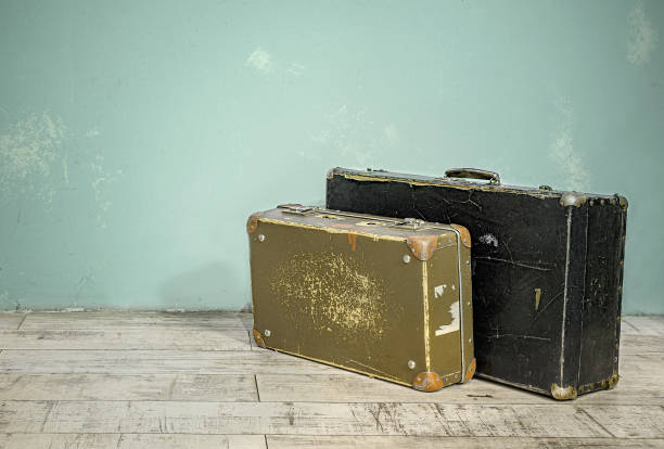 istock Old suitcases near the wall in an empty room 1155947408