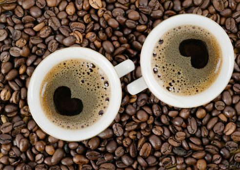 Background from coffee grains and a cup from coffee, the top vie