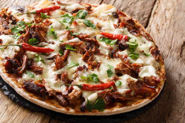 istock Homemade pizza with pulled pork, cheese, pepper and barbecue sauce close-up. horizontal, rustic style 1155947664