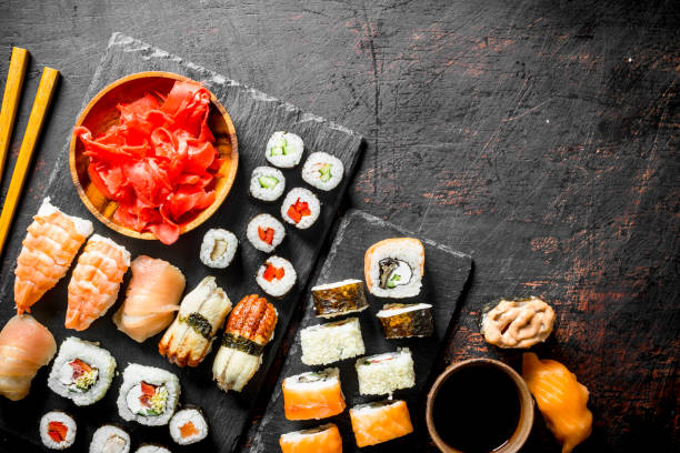 istock Fresh sushi rolls on black stone stand. 1155948263