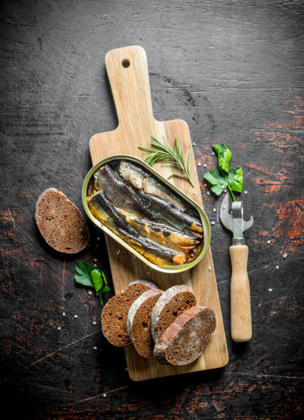 istock Sprats with slices of bread on the cutting Board. 1155948430