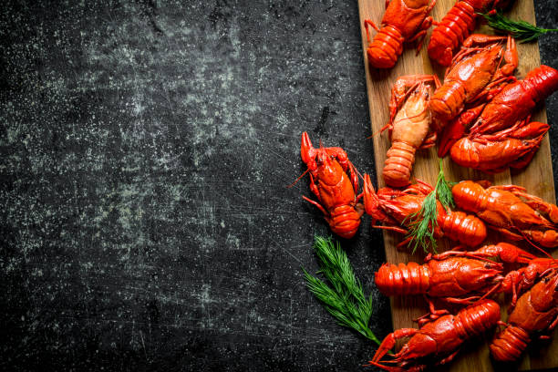 istock Boiled crayfish on a wooden cutting Board with dill. 1155949444