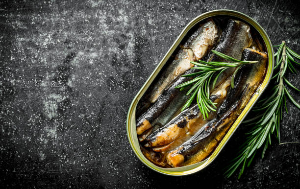 istock Sprats in a tin can of rosemary. 1155949611