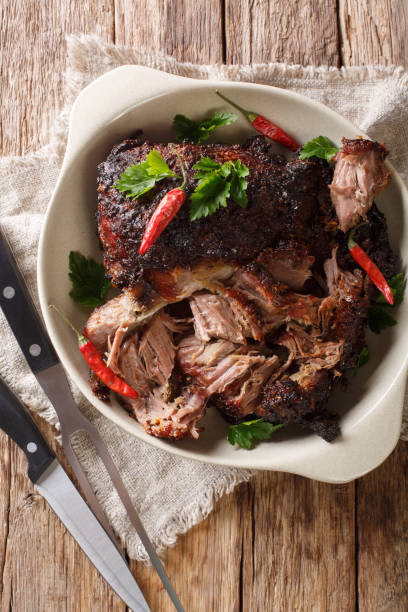 istock Delicious spicy slow shredded pulled pork closeup on a plate. Vertical top view 1155949626