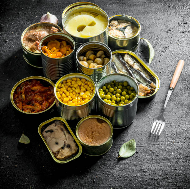 istock Open cans of mushrooms, pineapples, corn and canned fish. 1155951189