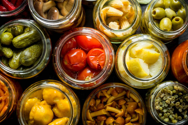 preserved vegetables in glass jars. - cucumber pickled imagens e fotografias de stock