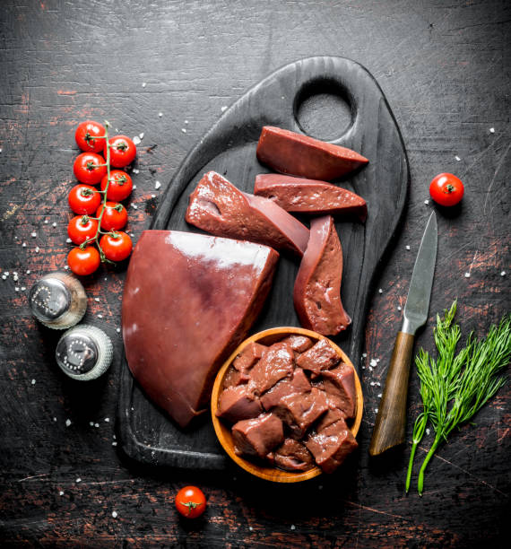 istock Raw liver with cherry tomatoes, spices and dill on a cutting Board. 1155951372