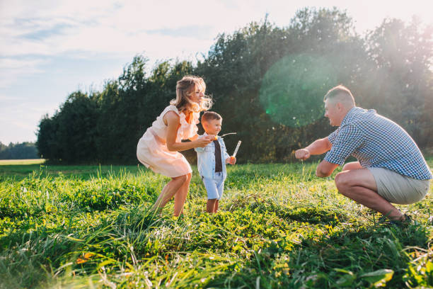 istock Happy family blowing soap bubbles in summer day. 1155951403