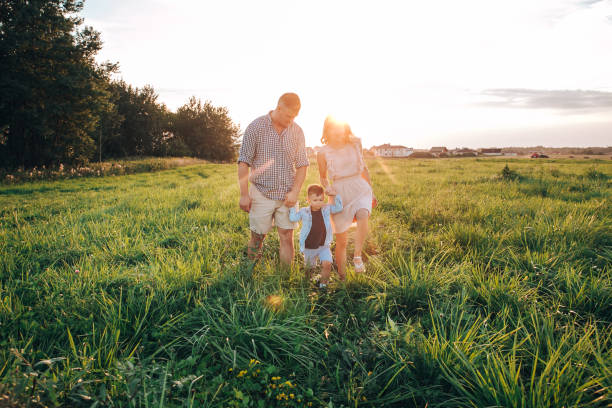 istock Happy boy with parents running in park. 1155952060