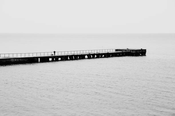 istock Old pier with alone fisher 1155952134