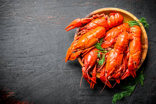 istock Boiled crayfish on a wooden plate with dill. 1155952265
