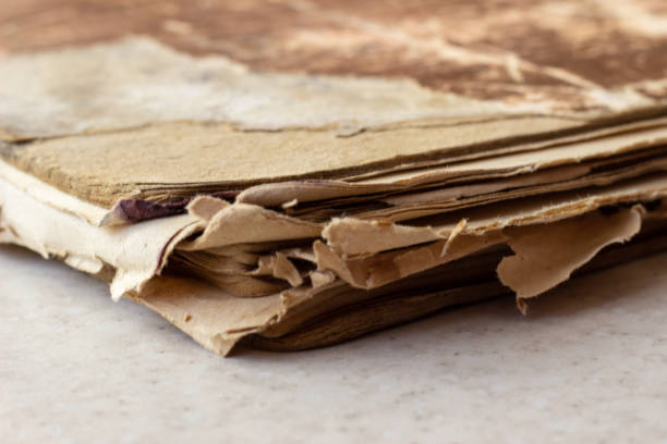 istock Old book on white surface. Disheveled book. A worn-out book on a white surface. A worn-out book on a white background 1155952299