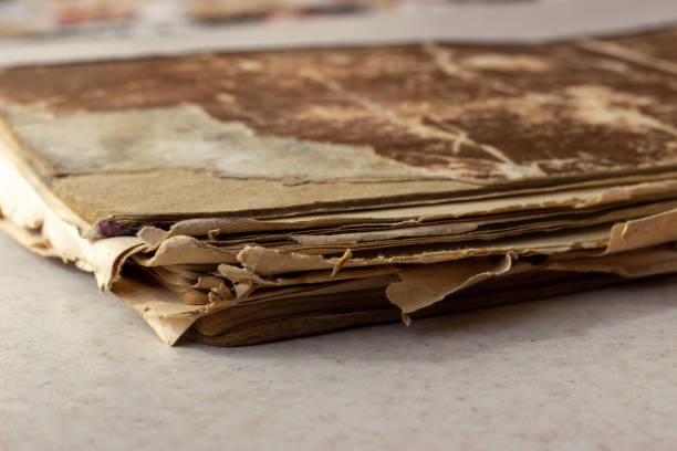 istock Old book on white surface. Disheveled book. A worn-out book on a white surface. A worn-out book on a white background 1155952311